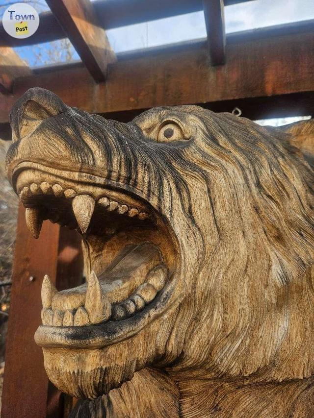 Photo of 7 foot tall solid teak hand carved bear with fish.