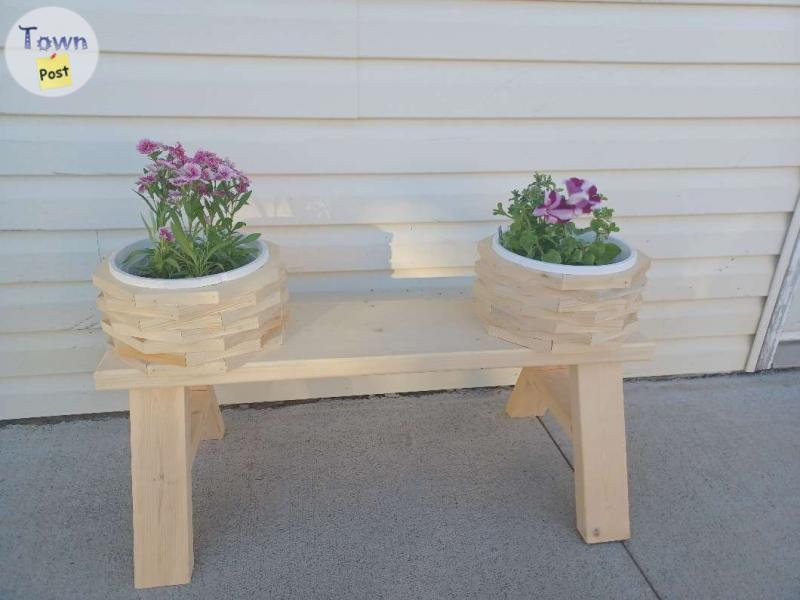 Photo of Wooden bench with flower pots