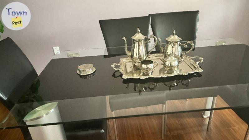 Photo of Elegant and classy solid table with matching leather chairs.